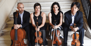 4 people sitting on stairs and holding instruments