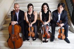 4 people sitting on stairs and holding instruments