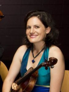 Person wearing a blue sleeveless top and holding a viola