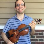 Person wearing a blue striped polo shirt, holding a violin