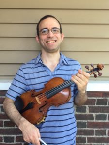 Person wearing a blue striped polo shirt, holding a violin