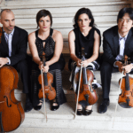 4 people sitting on stairs and holding instruments