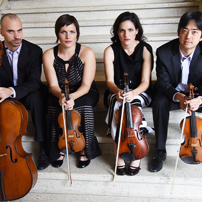 4 people sitting on stairs and holding instruments